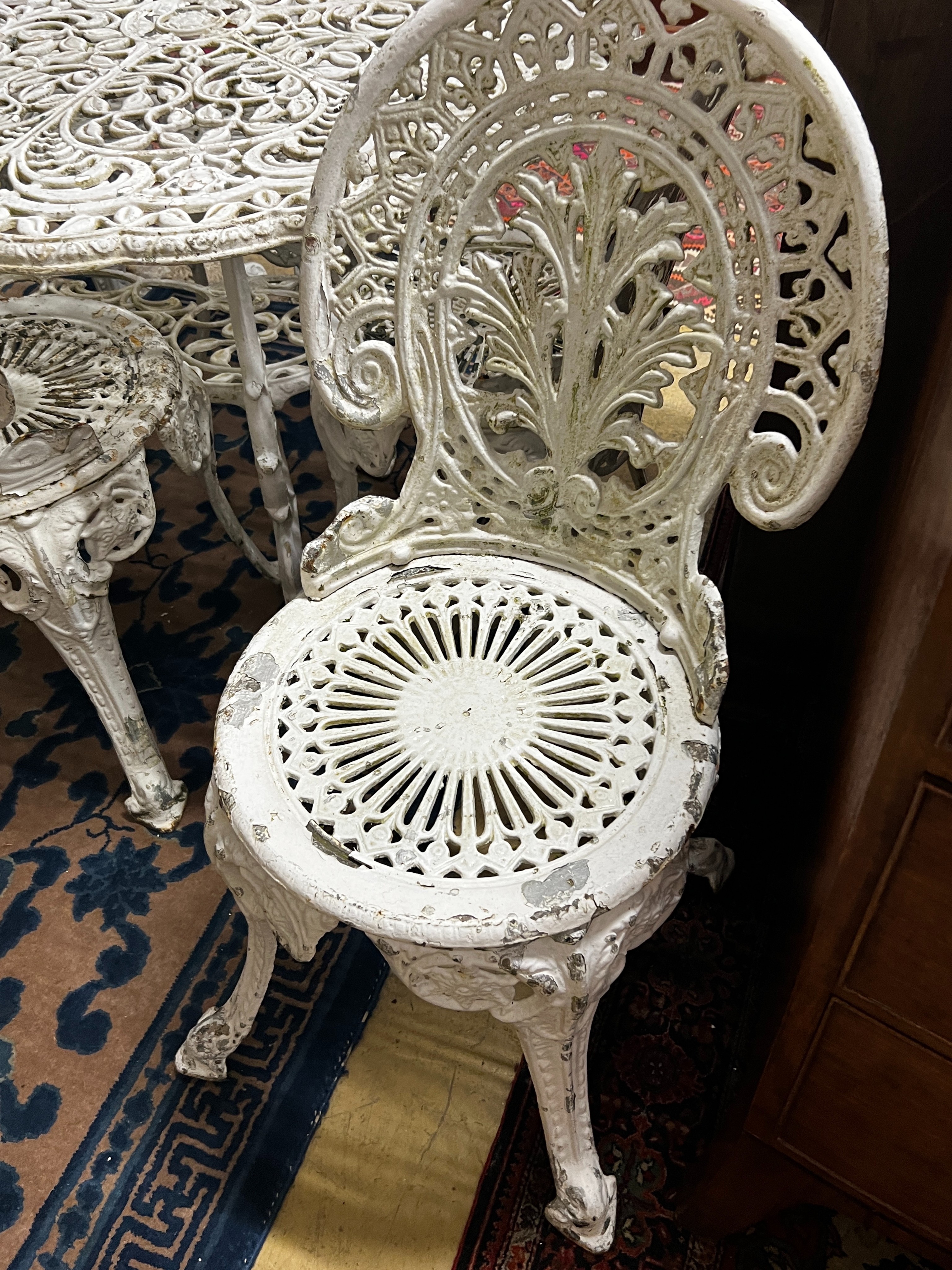 A Victorian style cast aluminium garden table, width 160cm, depth 90cm, height 67cm and six cast iron garden chairs